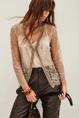 Saco de encaje con diseño floral y detalles bordados en hilo dorado. Presenta mangas tres cuartos, escote en V y bordes con terminación de puntilla. El diseño es abierto al frente con una estructura delicada y elegante.