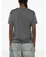 Remera de manga corta color gris oscuro con acabado satinado, de corte clásico y holgado, con cuello redondo.