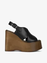 Sandalia negra con plataforma de madera y tira trasera ajustable con hebilla.