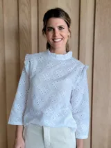 Blusa blanca con cuello mao con volados, mangas 3/4 con volados y calados con motivos florales.