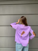 Cardigan tejido fino en lana color lila, con detalle de cintas y corte holgado.