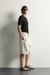 Remera relaxed fit confeccionada en tejido ligero de lyocell, de color negro con cuello redondo, manga corta y acabados en efecto doble combinado a contraste en color blanco.