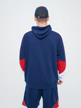 Canguro deportivo Umbro del Club Nacional de Football, modelo Nexo para hombre. Diseño en color azul marino con mangas rojas y detalles en celeste y blanco, capucha con cordón ajustable y bolsillo tipo canguro.