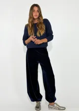 Pantalon de terciopelo azul marino, de corte holgado y tiro medio, con cintura elástica y puños ajustados en los tobillos.