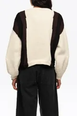 Cardigan de punto con diseño de bloques de color en blanco, negro y marrón, escote redondo y cierre frontal con múltiples lazos de tela.