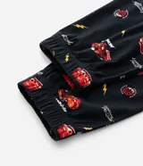 Pantalón de pijama de plush color negro con estampado integral de Cars, incluyendo a Rayo McQueen, el número 95 y rayos. Cuenta con cintura elástica con cordón de ajuste y puños en los tobillos.