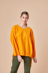 Remera italiana de algodón color naranja, de corte holgado, mangas largas y cordón ajustable en el ruedo.