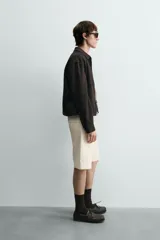 Sobrecamisa regular fit color gris oscuro, confeccionada en tejido con viscosa. Presenta cuello solapa, manga larga con puño abotonado, bolsillos de vivo en la cadera y cierre frontal con cremallera.