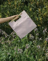 Bolso de mano tipo tote bag color rosa charol, con manija rígida de acrílico color madera.