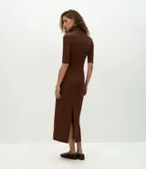Vestido midi de color marrón, confeccionado en tejido de poliéster con elastano. Presenta un diseño ajustado al cuerpo, cuello alto, mangas 3/4 y una abertura trasera en el bajo para mayor movilidad. Incluye un cinturón fino del mismo tono.