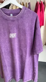 Remera de corte oversize con efecto lavado (washed) que le da un aspecto vintage y textura suave. Presenta un pequeño logo centrado en el pecho.