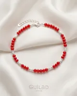 Pulsera de plata 925 con cuentas facetadas de cristal rojo y pequeños tubos plateados intercalados. Incluye cadena de alargue y cierre de mosquetón.