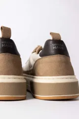 Championes urbanos de diseño moderno, combinando paneles de cuero texturizado en tono tostado y cuero liso en color crema. Presenta una suela de plataforma robusta en tono crema con un detalle en bloque tostado en el talón y un contrafuerte oscuro.