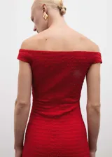 Vestido midi entallado de color rojo, con cuello barco y hombros descubiertos. Presenta un tejido con textura y abertura posterior en el bajo.