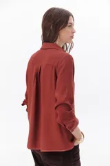 Blusa blanca de manga larga con escote en V y cuello camisero.