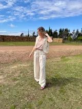 Pantalón de lino color beige, de corte ancho y holgado, con tabla frontal que aporta estructura y caída, y bolsillos laterales.