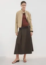 Falda midi evasé de tiro medio, color marrón oscuro, con diseño cruzado frontal y cierre de cremallera en la parte posterior, cuenta con forro interior.