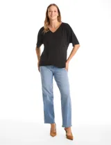 Blusa de silueta fluida con escote en V, manga japonesa corta y costura central vertical en el frente. Confeccionada en tejido de punto con acabado mate, presenta un diseño con largo asimétrico, siendo más larga en la espalda.