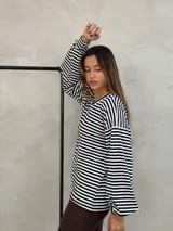 Sweater de punto con diseño de rayas horizontales en blanco y negro, de corte holgado y mangas largas.