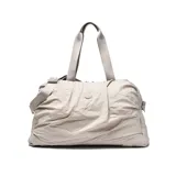 Bolso deportivo de gran capacidad con diseño arrugado, color gris claro. Cuenta con doble asa superior, correa ajustable y desmontable, y correas en la base para sujetar accesorios. Incluye compartimento principal con cierre, bolsillo frontal y bolsa interior desmontable.