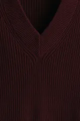 Buzo de punto acanalado en color bordó, con cuello en V y detalles de rayas blancas en contraste en los puños y el ruedo. Presenta un corte boxy que ofrece una silueta amplia y estructurada.