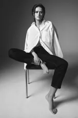 Jeans de tiro medio con corte slim leg, confeccionados en denim color beige. Presentan cintura con trabillas, diseño clásico de cinco bolsillos y cierre frontal con cremallera y botón metálico.