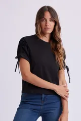 Remera negra de manga corta con cuello redondo y fruncidos ajustables mediante cordones en las mangas.
