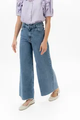 Jean de corte wide leg con diseño de tiro alto y ruedo deshilachado. Presenta un acabado con textura de pequeños tajos en la tela, brindando un estilo moderno y versátil.