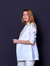 Blazer de lino color blanco, de corte recto y doble botonadura con botones color beige.