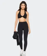Top deportivo Fabletics modelo PureLuxe color verde militar, con diseño cruzado en la parte delantera y tirantes halter.
