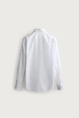 Camisa de corte slim fit, color celeste, con cuello italiano y manga larga con puños abotonados. Presenta un tejido con textura y cierre frontal de botones.