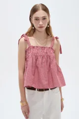 Musculosa de lino con estampado de cuadros vichy en rojo y blanco, escote recto y tirantes anchos con lazos para anudar en los hombros.