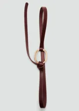 Cinturón fino bordó de poliuretano, con hebilla metálica redonda dorada y diseño ajustable mediante nudo.