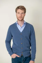 Cardigan de lana merino en color azul, con escote en V, cierre frontal de botones y bolsillos laterales.