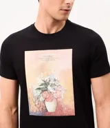 Remera negra de manga corta y cuello redondo, confeccionada en mezcla de algodón y poliéster, con estampa frontal rectangular que reproduce la obra artística "Vase of Flowers" de Odilon Redon.