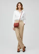 Cartera bandolera de cuero color marsala (terracota/rojizo), con solapa y cierre de cremallera.