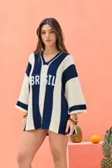 Remerón tejido de punto oversize, con diseño de rayas verticales en colores crudo y azul marino. Cuenta con escote en V y la palabra "BRASIL" estampada en el frente.