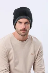 Gorro tejido reversible de diseño bicolor, con una cara en color negro y otra en gris, confeccionado en punto acanalado.
