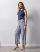 Pantalón de lino a rayas verticales en tonos azul, beige y blanco, con corte wide leg, pretina con pasadores, cierre y botón. Incluye cinturón de soga con hebilla redonda.