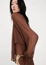 Blusa marrón de viscosa con cuello alto, volados y mangas largas acampanadas con puños elastizados.
