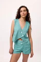 Chaleco blanco de lino y algodón, con escote en V y cierre frontal de botones.