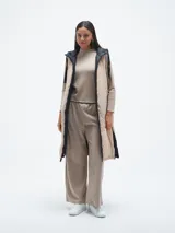 Chaleco largo acolchado color negro con capucha y cierre frontal.