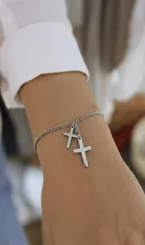 Pulsera de cadena de acero con dos dijes colgantes en forma de cruz.