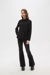 Camisa de poliéster color crema con estampado de pequeños puntos negros, cuello clásico, cierre frontal con botones y mangas largas con puños abotonados.