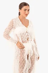 Vestido playero largo de encaje blanco con volados, mangas largas, abertura frontal con lazos para cerrar y aberturas laterales.