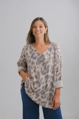 Sweter de punto con escote en V y mangas largas con puños vueltos. Presenta un diseño holgado con estampado animal print en tonos neutros.