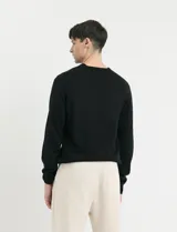Sweater de punto con escote en V y manga larga, con puños y ruedo acanalados.