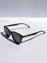 Lentes de sol Osten modelo Maui, con armazón negro de diseño redondeado y detalles en color naranja en las patillas. Cuentan con cristales polarizados con protección UV 400.