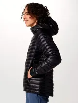 Campera puffer ultraligera Mountain Hardwear, modelo Ghost Whisperer, color negro. Confeccionada en tejido ripstop reciclado con aislamiento de plumón de 800 hilos. Cuenta con capucha, cierre frontal completo, dos bolsillos laterales con cremallera y diseño altamente compactable.