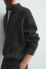 Chaqueta relaxed fit de tejido de punto de algodón, color verde militar, con cuello subido, manga larga, acabados en rib y cierre frontal con cremallera. Presenta efecto lavado.